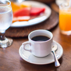 A cup of coffee in front of a breakfast plate background